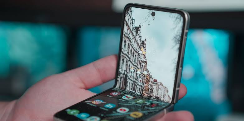 Foldable smartphone opened at an angle showing the flexible display and app interface.