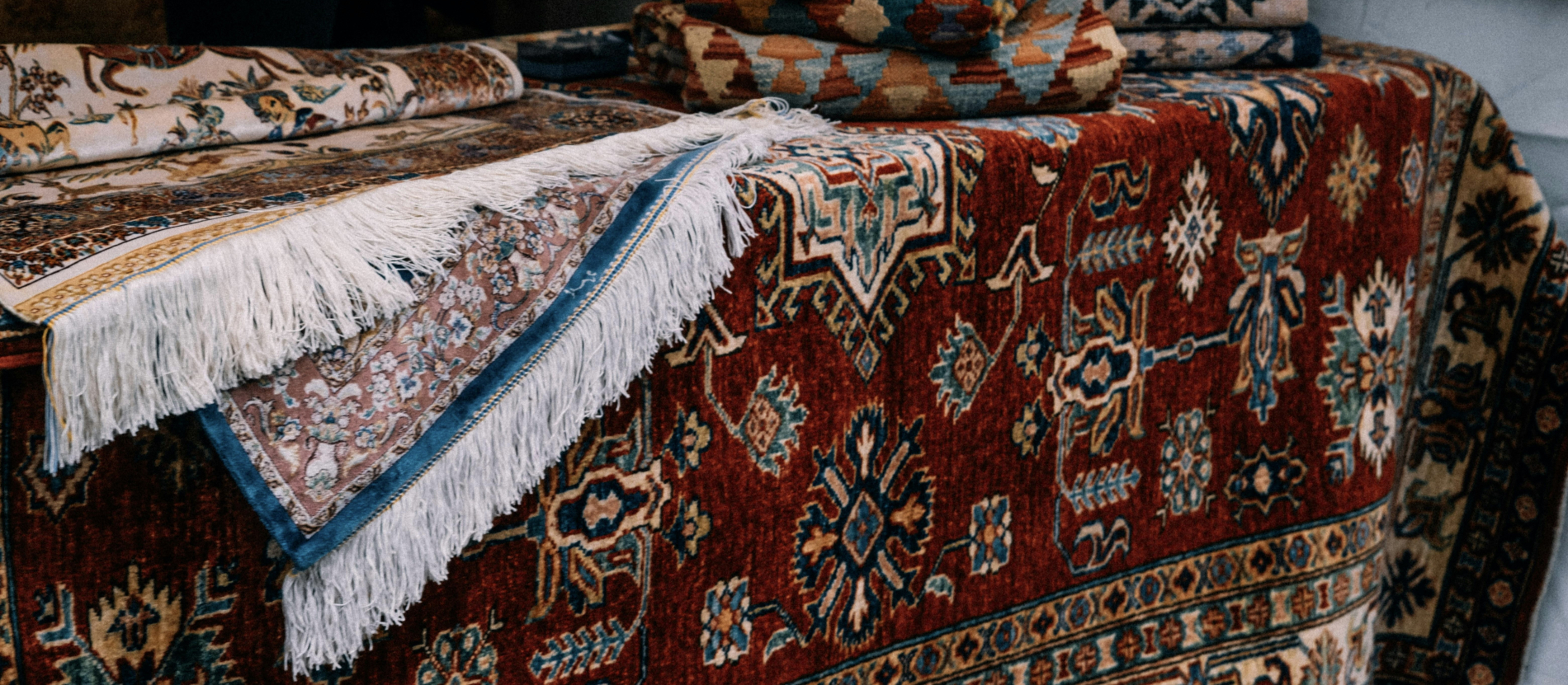 Traditional Persian rugs with colorful patterns and decorative fringes displayed together.