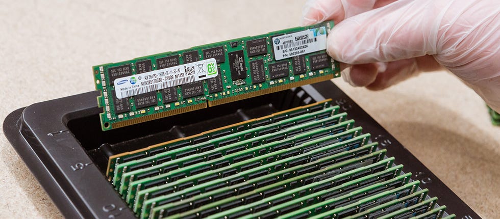 Person installing a RAM module into a computer memory slot.