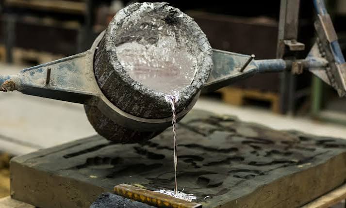 Molten silver being poured from a crucible into a casting mold