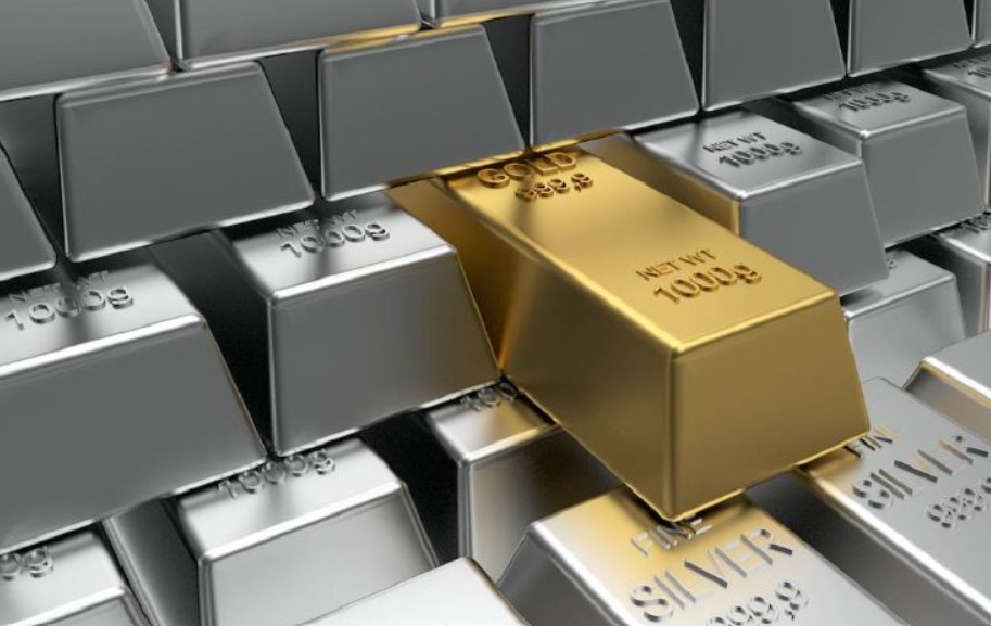 Gold bar surrounded by stacked silver bars and bullion ingots