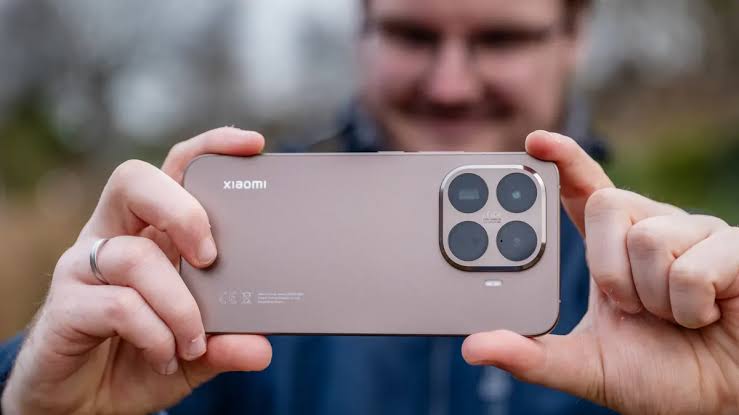 Person holding a Xiaomi smartphone to showcase its rear camera system.