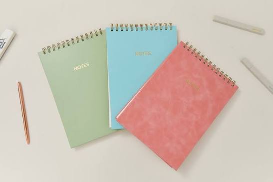 Pastel spiral notebooks in green, blue, and pink colors