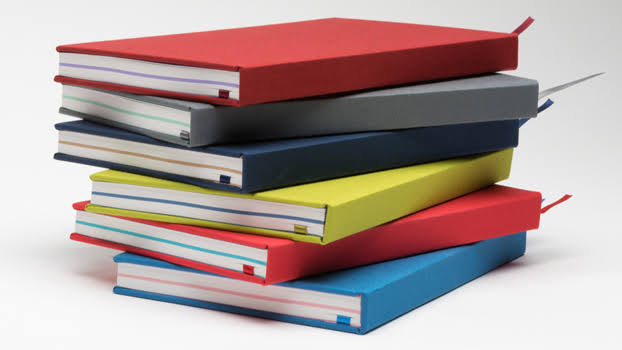 Stack of colorful hardcover notebooks on a white background
