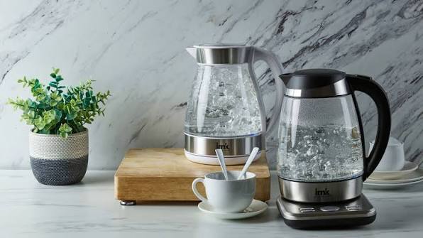 Glass tea makers with boiling water on a kitchen counter