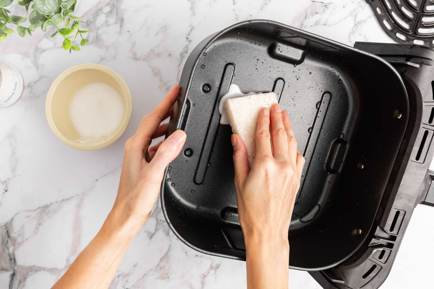 Cleaning an air fryer basket with a sponge