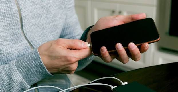 Connecting a charging cable to a smartphone
