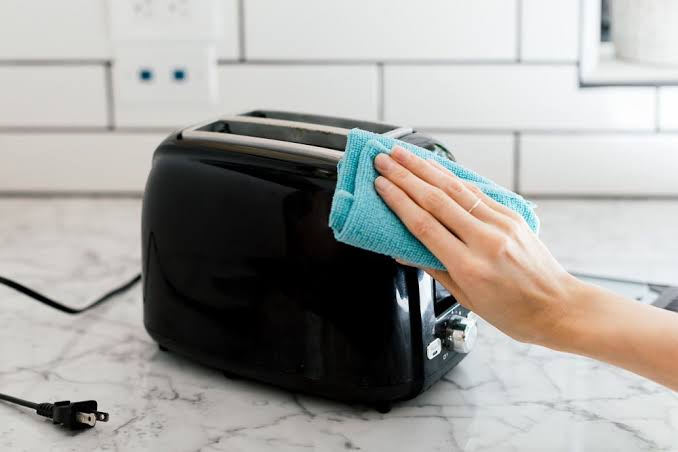 Cleaning a toaster with a microfiber cloth