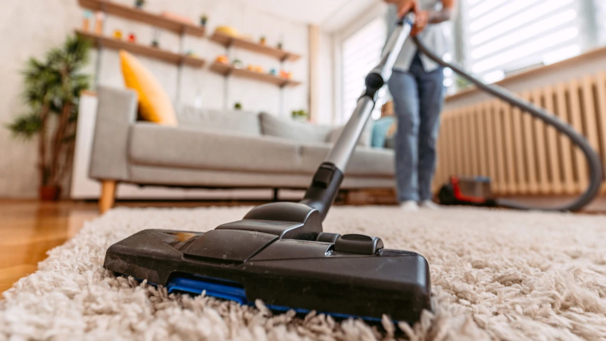 Vacuum cleaner cleaning a carpet in a living room