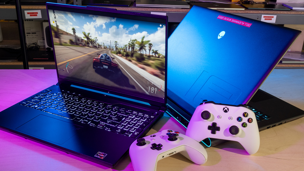 Gaming laptops with Xbox controllers displaying a racing game