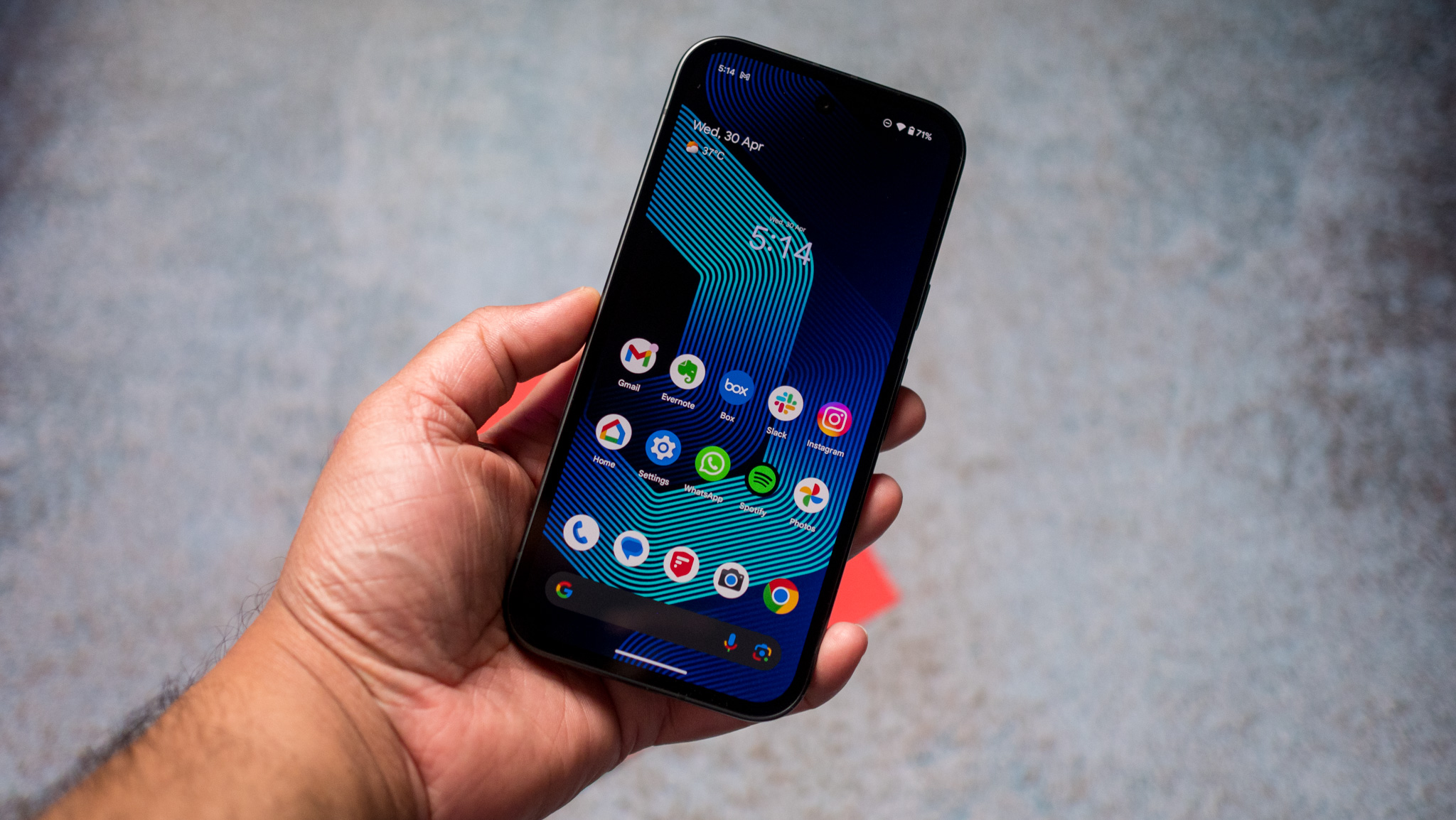 Android smartphone held in hand showing apps on the home screen
