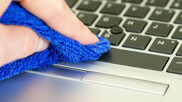 Cleaning a laptop keyboard and touchpad with a microfiber cloth
