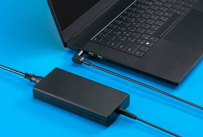 Laptop connected to an external power adapter for safe and proper battery charging