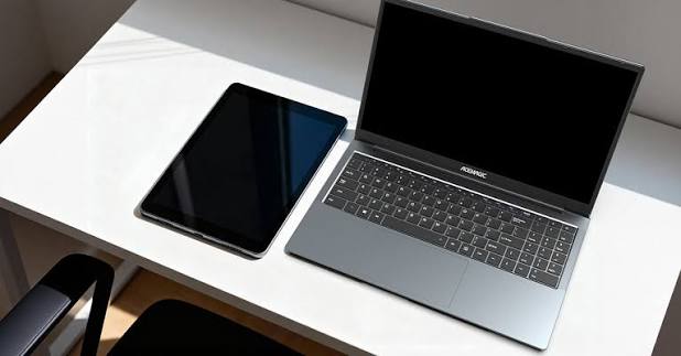 Laptop and tablet placed side by side on a desk